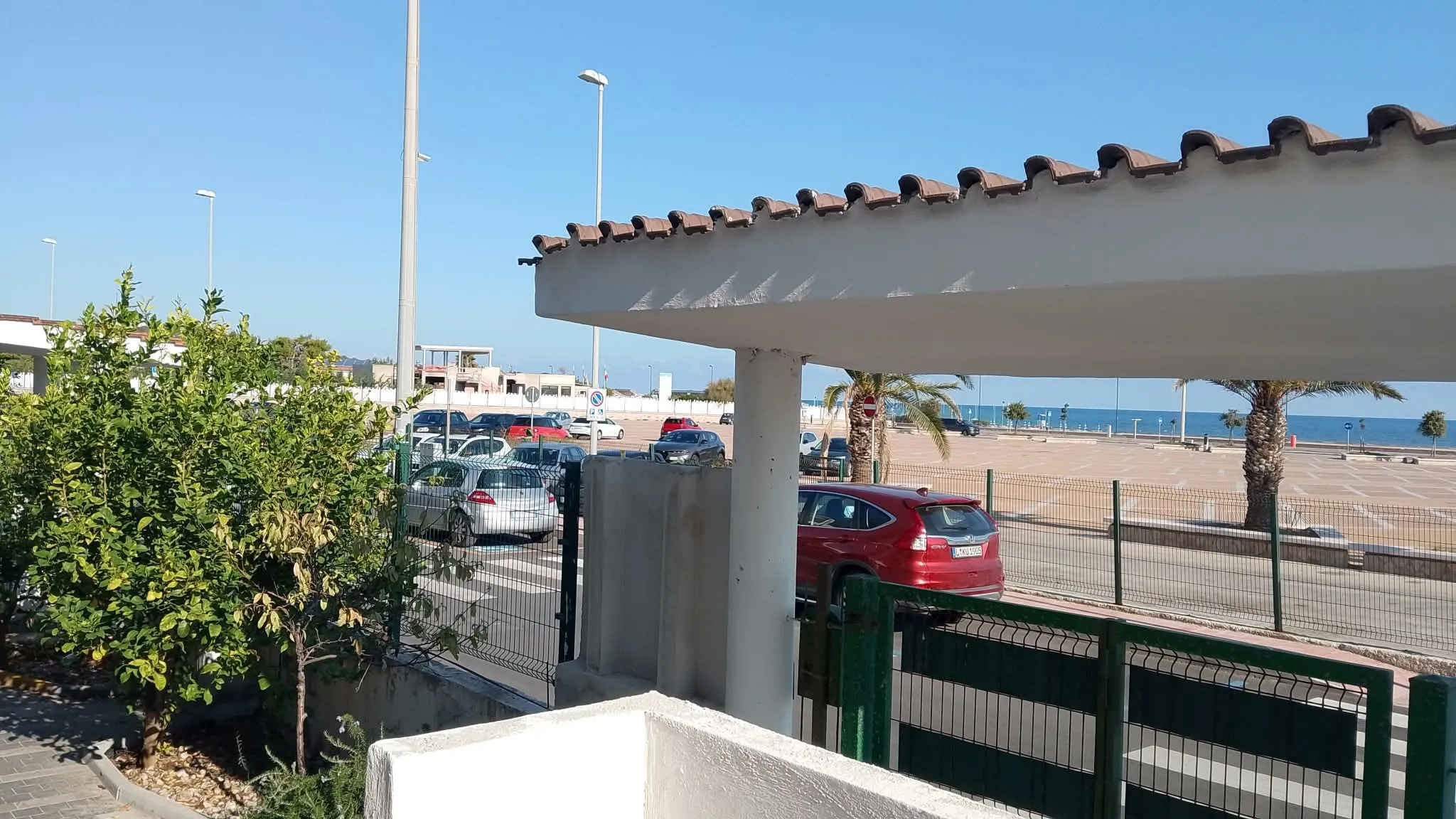 Appartamento 3a: il terrazzino con la pergola; oltre la recinzione, il piazzale e il mare