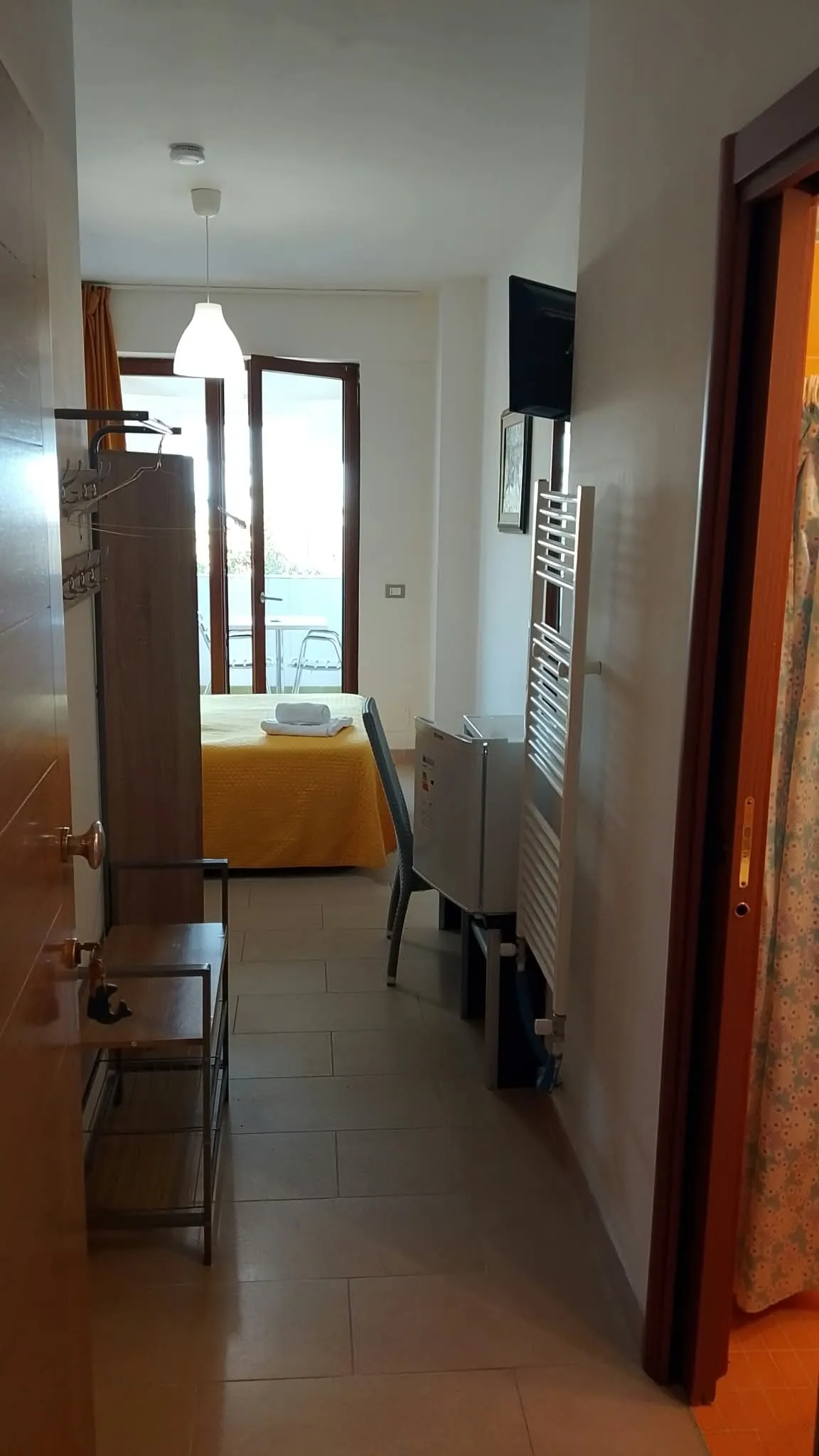 Camera 1b: l’ingresso, col letto e la porta finestra in fondo