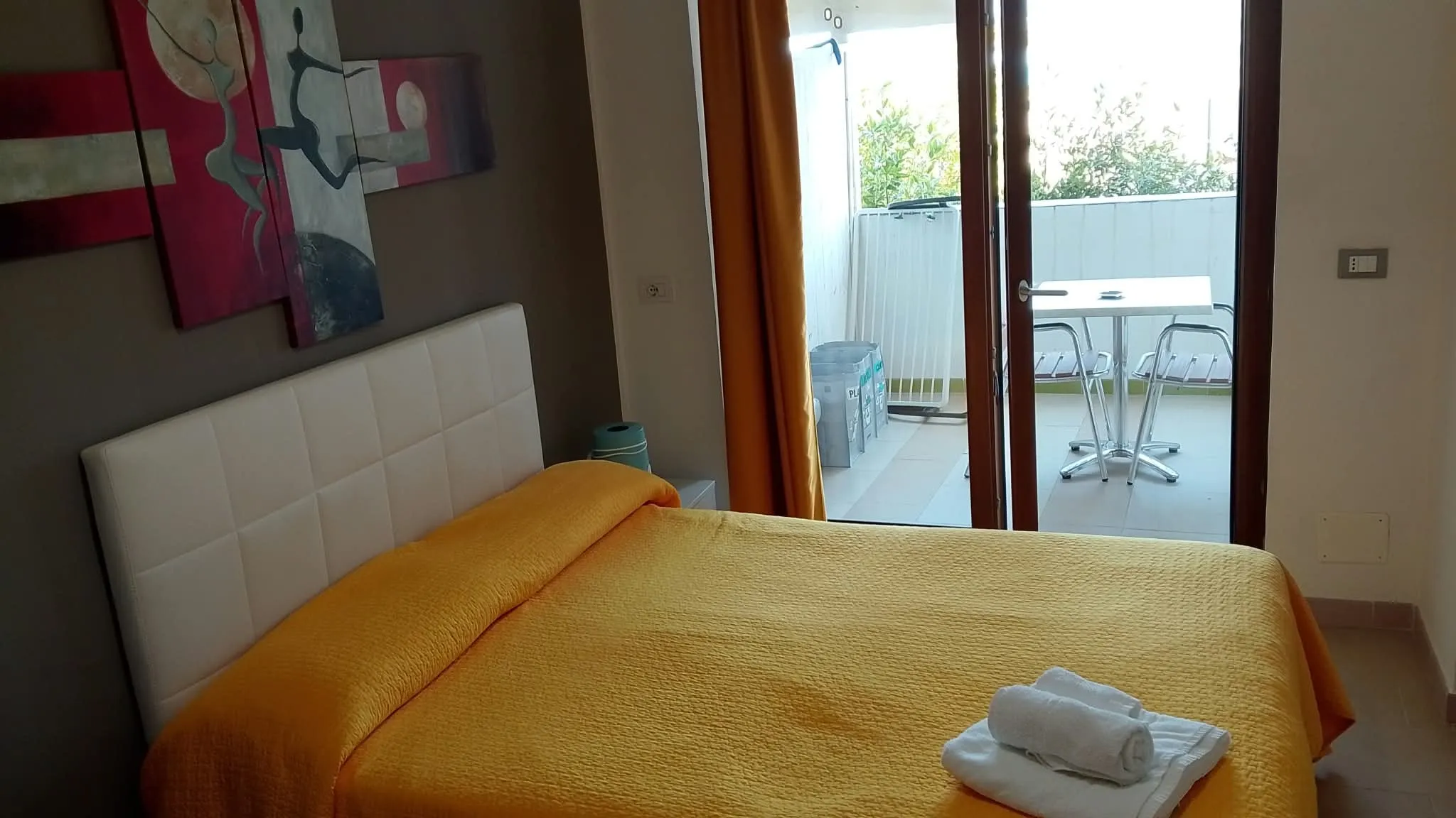Camera 1b: il letto a testiera bianca e la veranda