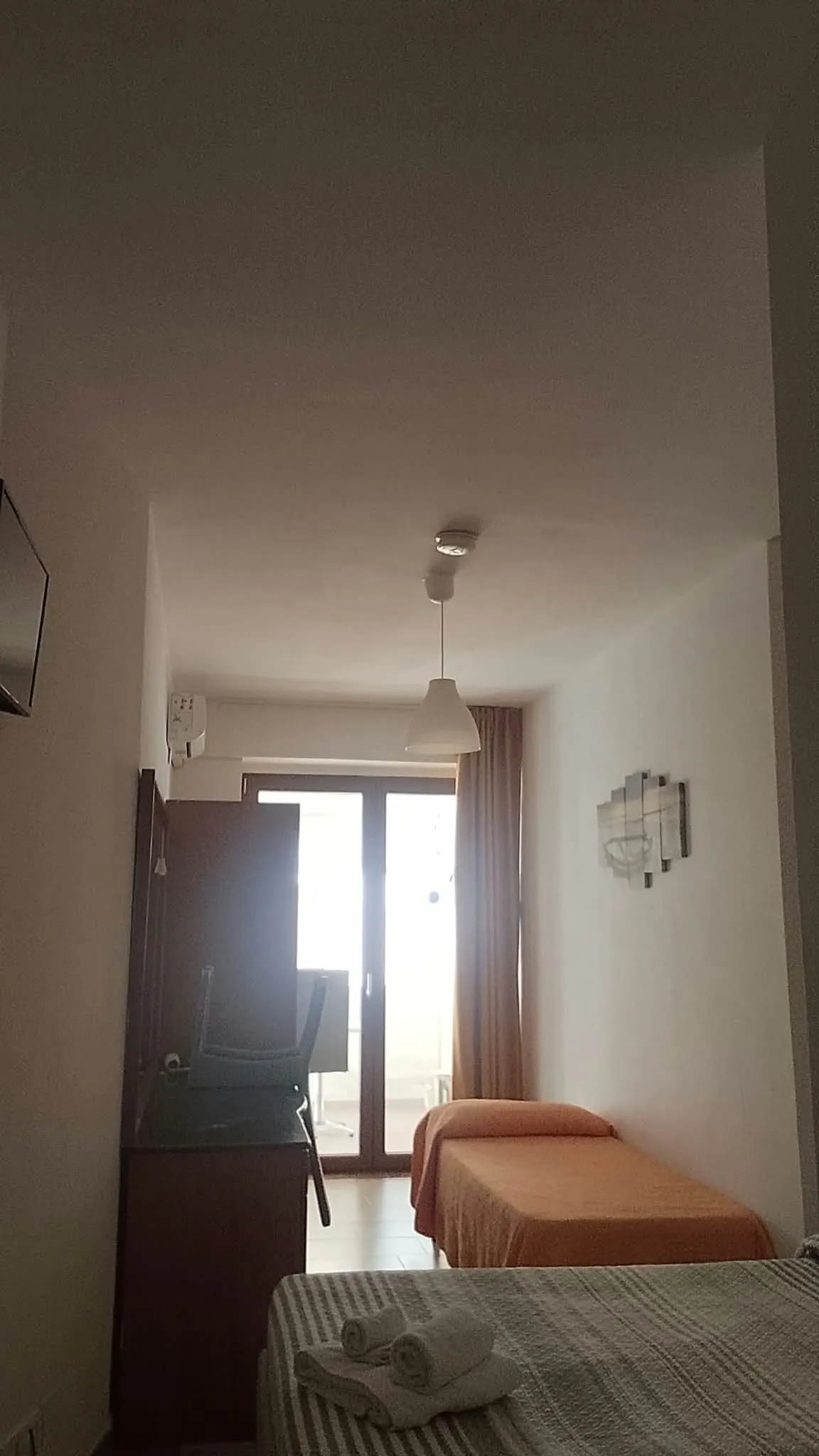 Camera 2b: l’ingresso, coi due letti e la porta finestra in fondo