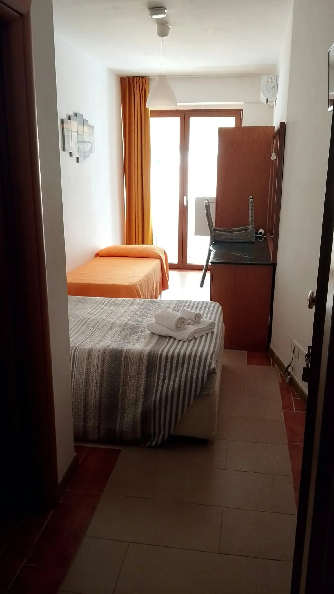 Camera 5b: l’ingresso, coi due letti e la porta finestra in fondo