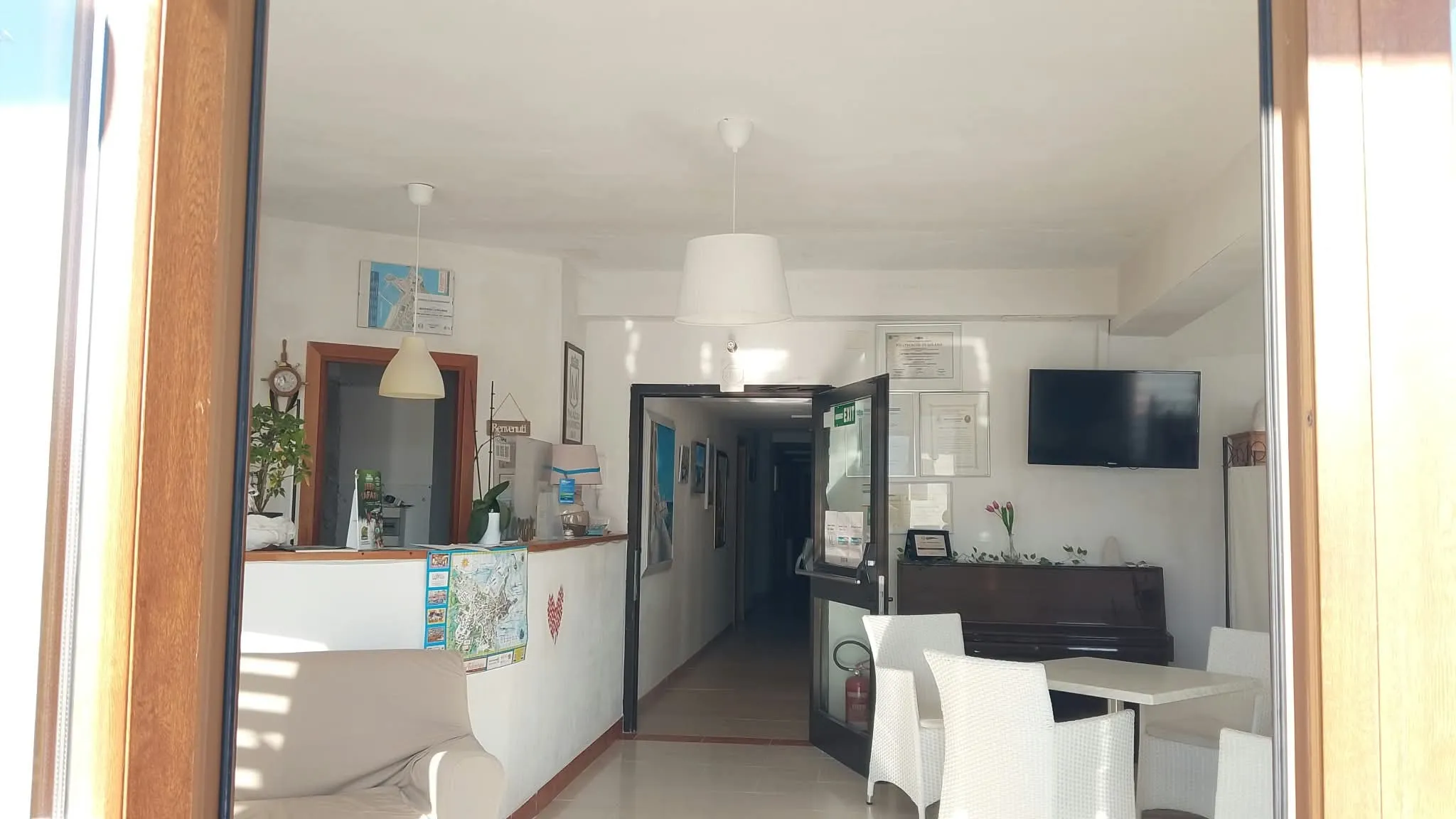 Il bancone dell’accettazione visto dalla porta, col corridoio in fondo